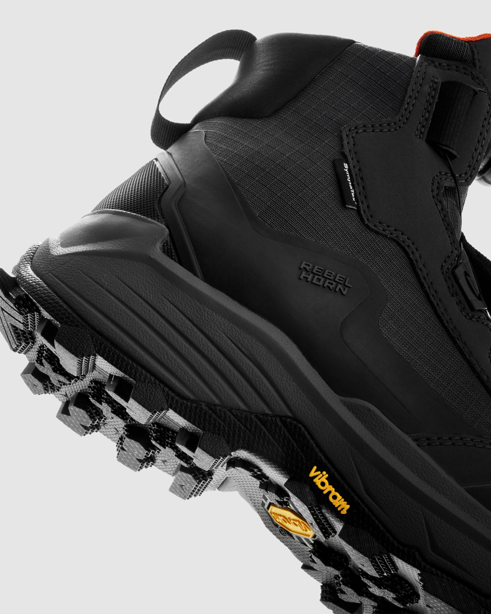 Black boot with Vibram sole on a light gray background