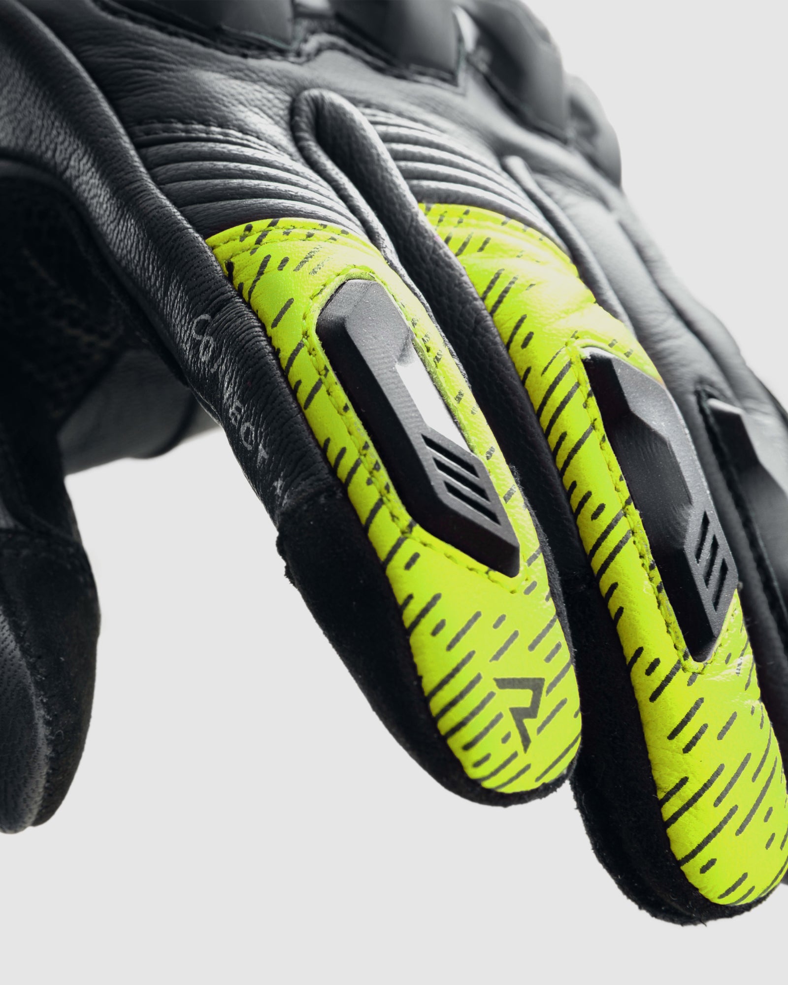 Pair of black and yellow gloves with a brand logo on a light gray background